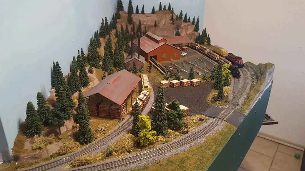 A detailed HO scale model train layout featuring Peco Code 100 turnouts, realistic landscapes.