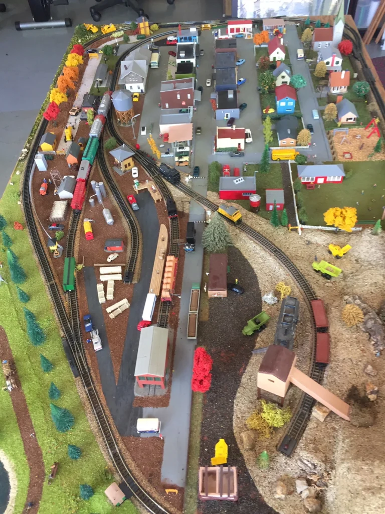 HO scale Bachmann EZ Track layout on 4x8 ft board, featuring small town, green scenery, and 1950s-style railroad.